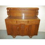 AN OAK MID CENTURY SIDEBOARD WITH CARVED DETAIL