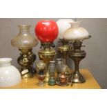 A COLLECTION OF OIL LAMPS TOGETHER WITH THREE PICTURE FRAMES