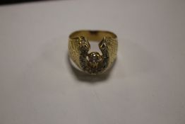 A HORSESHOE RING, POSSIBLY 18 CT YELLOW METAL