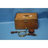 A WOODEN BOX CONTAINING A LETTER OPENER, MAGNIFYING GLASS AND A TAPE MEASURE