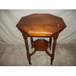 AN EDWARDIAN TWO TIER OCTAGONAL TABLE ON CASTORS