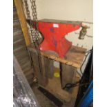 A VINTAGE RED ANVIL ON WOODEN STAND