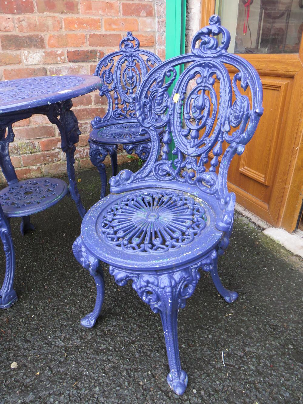 A HEAVY CAST IRON PURPLE PAINTED PATIO SET COMPRISING OF TABLE AND FOUR CHAIRS - Image 3 of 4