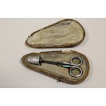 AN ANTIQUE SILVER THIMBLE AND SCISSORS SET IN FITTED CASE