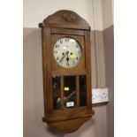 AN EDWARDIAN OAK WALL CLOCK