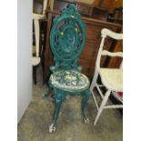 A HEAVY CAST IRON GREEN PAINTED OUTDOOR CHAIR WITH FIGURATIVE DETAIL