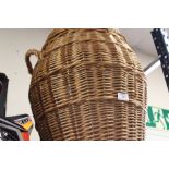 A TWIN HANDLED WICKER LAUNDRY BASKET