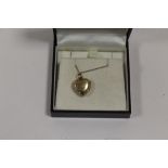 A LADIES 9CT GOLD BK&FT HEART SHAPED LOCKET ON CHAIN