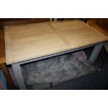 A MODERN OAK EFFECT EXTENDING DINING TABLE