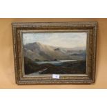 A GILT FRAMED OIL ON CANVAS DEPICTING A MOUNTAINOUS RIVER SCENE