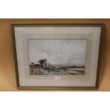 A GILT FRAMED AND GLAZED WATERCOLOUR OF A COUNTRY LANDSCAPE INDISTINCTLY SIGNED LOWER LEFT