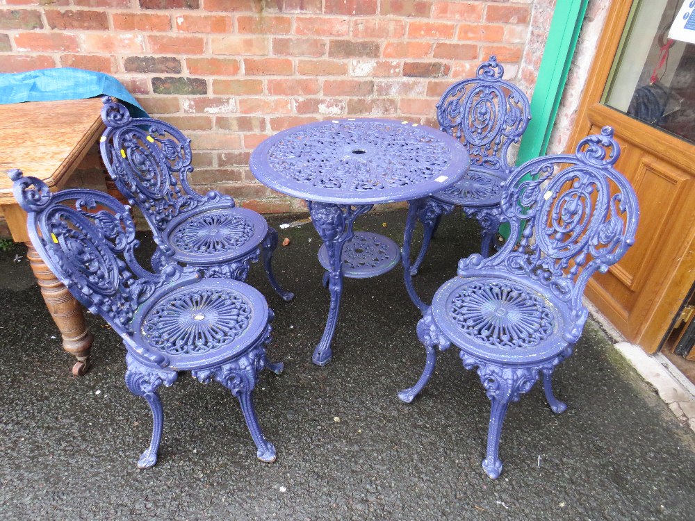 A HEAVY CAST IRON PURPLE PAINTED PATIO SET COMPRISING OF TABLE AND FOUR CHAIRS