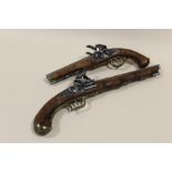 A REPRODUCTION DOUBLE BARREL DECORATIVE FLINT LOCK PISTOL TOGETHER WITH A SINGLE BARREL EXAMPLE