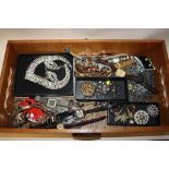 A WOODEN TRAY OF COSTUME JEWELLERY AND WRISTWATCHES ETC.