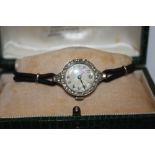 A LADIES VINTAGE PLATINUM AND DIAMOND SET WATCH - EACH BRILLIANT CUT DIAMOND APPROX 0.02 CARATS -