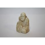 A VINTAGE NETSUKE IN THE FORM OF A KNEELING MAN