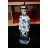 AN ORIENTAL BLUE AND WHITE FIGURE WITH IMPRESSED STAMPS TO BASE