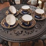 AN EARLY 20TH CENTURY DECORATIVE SET OF ROYAL WORCESTER CUPS AND SAUCERS, HEAVILY GILDED WITH ENAMEL