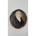 A GEORGIAN MINIATURE OF A GENTLEMAN IN GILT METAL FRAME