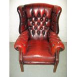 A RED OXBLOOD LEATHER DEEP BUTTONED WING BACK CHESTERFIELD STYLE CHAIR