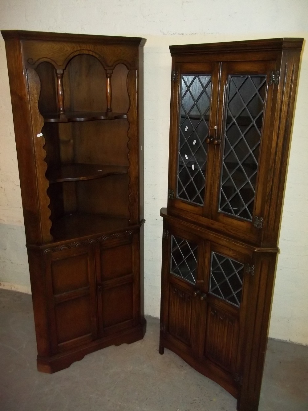 TWO EXCEPTIONAL OAK CORNER UNITS WITH LEADED GLASS AND LINEN FOLD DESIGN DOORS