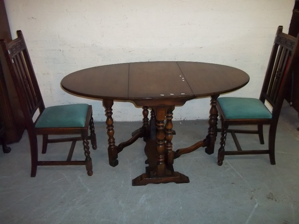 AN OAK DROP LEAF DINING TABLE WITH TWO CHAIRS