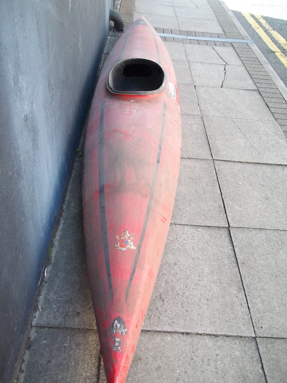 A SINGLE MAN CANOE WITH A DOUBLE ENDED OAR, HELMET ETC.