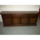 A HEAVY OAK PANELLED SIDEBOARD