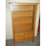 A MODERN LIGHT OAK BOOKCASE DISPLAY WALL UNIT WITH STORAGE DRAWERS