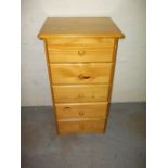 A NARROW PINE CHEST OF FIVE DRAWERS