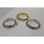 TWO HALLMARKED SILVER ENGRAVED BANGLES TOGETHER WITH A GOLD PLATED EXAMPLE
