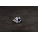 A VICTORIAN STYLE PLATINUM SAPPHIRE AND DIAMOND RING, set with a central oval-cut sapphire. The