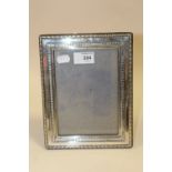 A HALLMARKED SILVER PHOTO FRAME OVERALL SIZE - 23 X 18 CM