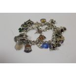 A STERLING SILVER CHARM BRACELET WITH ENAMELLED CHARMS