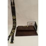 A LONG LEATHER MARTINGALE OF HORSE BRASSES AND A SNAKESKIN EFFECT DESK TIDY, FOLDER AND ANOTHER (4)