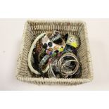 A BASKET OF COSTUME JEWELLERY TO INCLUDE BANGLES, NECKLACES ETC.
