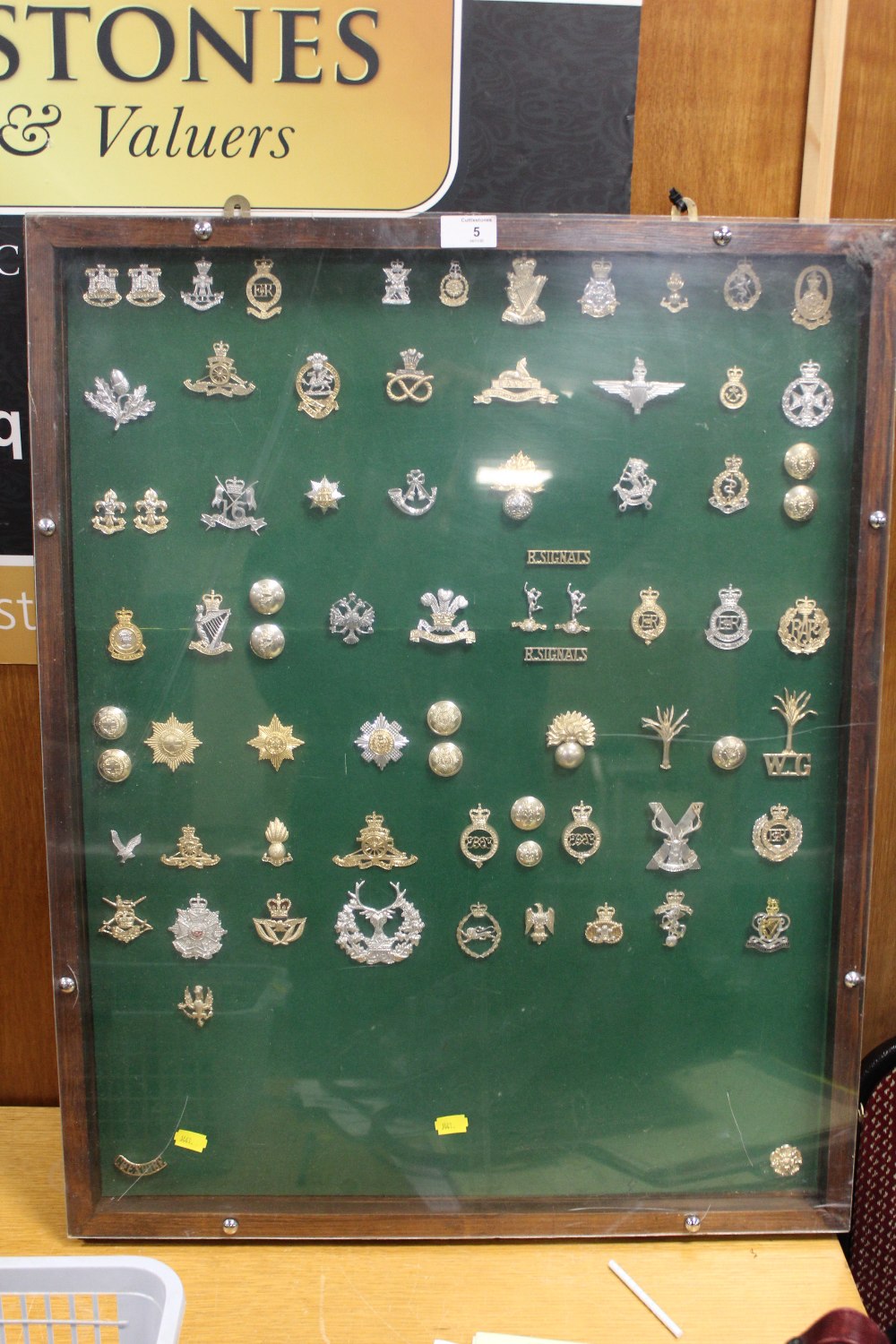 AN OAK DISPLAY CASE CONTAINING A DISPLAY OF VINTAGE MILITARY BADGES AND BUTTONS ETC.