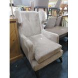 A MODERN UPHOLSTERED WINGBACK ARMCHAIR