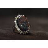 A WHITE GOLD BLACK OPAL AND DIAMOND RING. boxed. Black opal 13.16ct. Diamonds 1.14ct, Ring size N