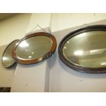 A CARVED OAK OVAL WALL MIRROR TOGETHER WITH ANOTHER OAK MIRROR AND A LARGER OVAL EXAMPLE (3)