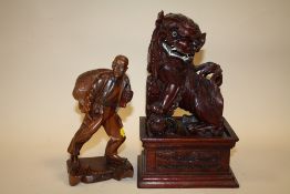 AN ORIENTAL CARVED HARDWOOD DOG OF FOE ON PLINTH TOGETHER WITH A CARVED HARDWOOD FIGURE OF A