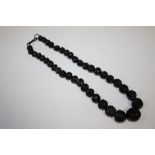 A CARVED WHITBY JET BEADED NECKLACE