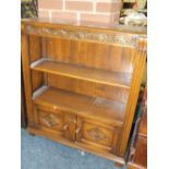 A REPRODUCTION CARVED OAK SMALL OPEN BOOKCASE WITH CUPBOARD BELOW H-95 CM W-84 CM