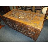 A CARVED EASTERN HARDWOOD COFFER WITH METAL DECORATIVE HINGES H-50 W-95 CM