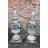 A PAIR OF LARGE STONE PEDESTAL URNS, supported on a squared foot leading to a solid swirling base,