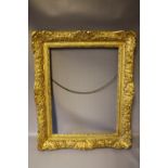 A MID 17TH CENTURY LOUIS XIV DECORATIVE GILT PICTURE FRAME, frame W 10 cm, framed rebate 58 x 45 cm