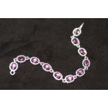 AN 18ct WHITE GOLD PINK SAPPHIRE AND DIAMOND OVAL LINE BRACELET, boxed. Pink sapphires 10.15ct.
