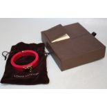 LOUIS VUITTON - A RESIN 'LOCK ME' HINGED BANGLE, with original box and Louis Vuitton drawstring bag