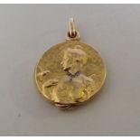 AN ART NOUVEAU DIAMOND SET YELLOW METAL PENDANT LOCKET, depicting a maiden with a bird in relief,