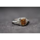 AN 18ct WHITE GOLD FANCY BROWN CUSHION CUT DIAMOND RING, with diamond halo and shoulders. Fancy